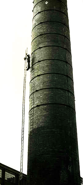 Old black and white picture of steeplejack working at old Chimney