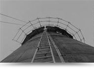 black and white photo of lader on big chimney