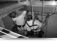 black and white photo of two steeplejacks who are working in a tight space 